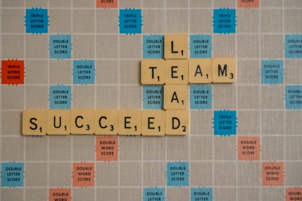 Team Lead Succeed, the title of the bestselling book about teamwork and leadership by Nick Fewings, Teamworkologist at Ngagementworks, spelled out in scrabble letters.